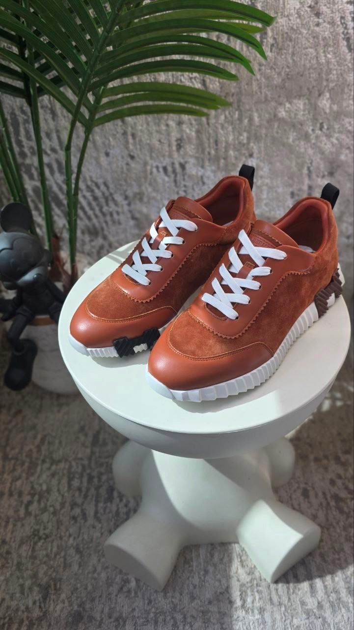 Hermès Bouncing Sneakers in gold, crafted from soft suede and calfskin with a distinctive ridged white rubber sole