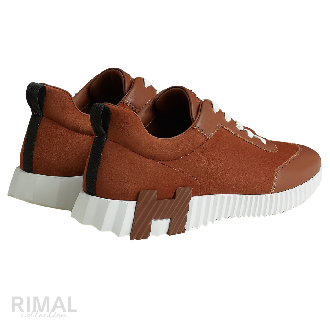 Hermès Bouncing Sneakers in gold, crafted from soft suede and calfskin with a distinctive ridged white rubber sole